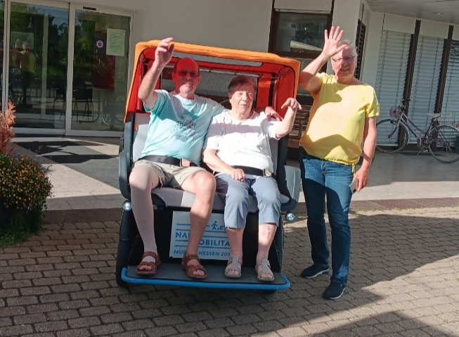 Rikscha mit zwei Fahrgästen und Fahrer.